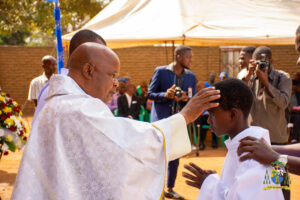 Monsignor Patrick Thawale administering the Sacrament of Confirmation to a young Christian at Maria Mthandizi wa Akhristu Parish — marking a historic first for the newly established parish.