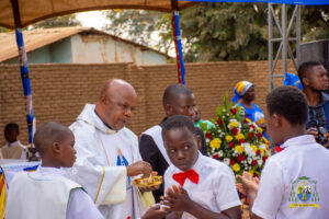 Newly confirmed youths receive the Holy Eucharist from Monsignor Patrick Thawale during the parish’s first-ever Confirmation Mass at Maria Mthandizi wa Akhristu Parish
