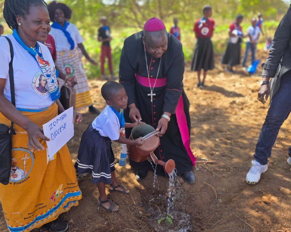Rt. Rev. Alfred Chaima and a child from the Catholic Diocese of Zomba water a tree, embodying the spirit of stewardship for creation.
