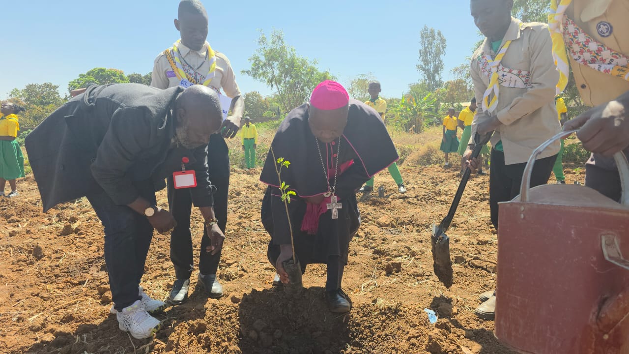 Bishop Martin Mtumbuka leads by example, planting a tree to teach children about environmental conservation