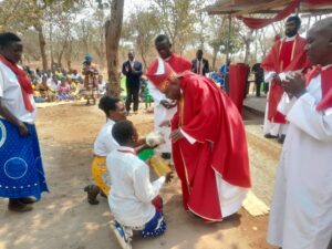 The newly confirmed youths presenting their gift to the Auxiliary Bishop