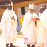 Auxilialy-Bishop-Mwakhwawa-handing-over-christians-register-book-to-the-Parish-priest-for-the-new-parish-Fr-Philp