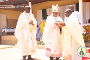 Auxilialy-Bishop-Mwakhwawa-handing-over-christians-register-book-to-the-Parish-priest-for-the-new-parish-Fr-Philp