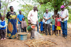 Chinkonda, watering his garden using a water cane