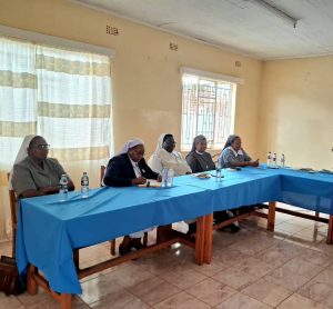 Sister Njeri in black jacket with the board of trustees during the meeting